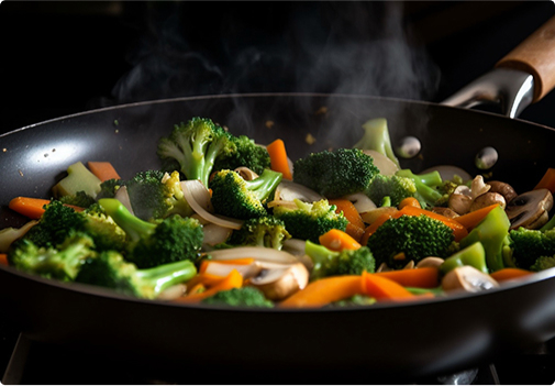 Broccoli being fried in a saute pan with other vegetables