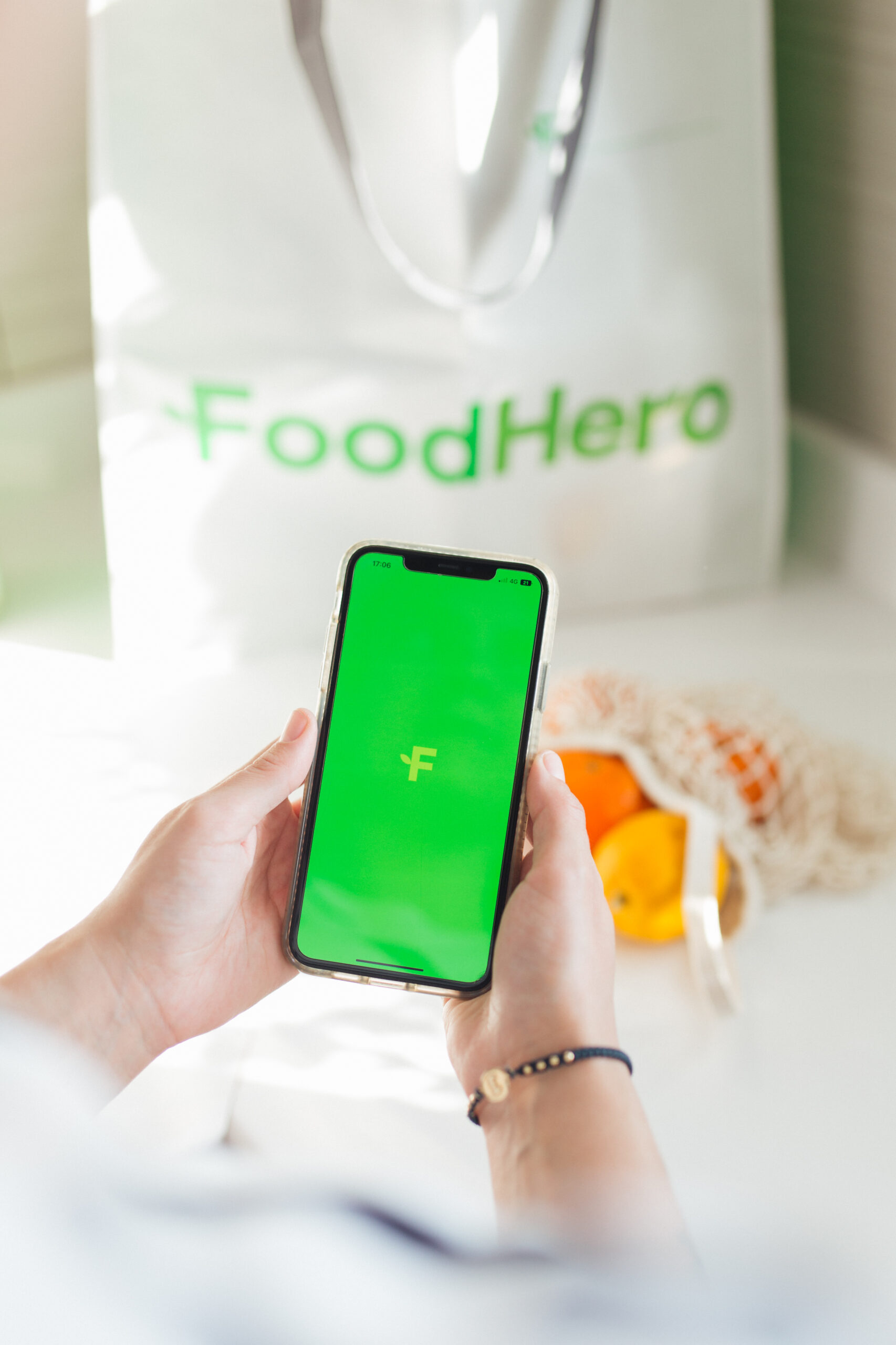 Phone with the FoodHero logo and a FoodHero shopping bag in the background